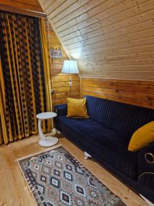 a living room with a blue couch and a table at Cozy Cottage A in Kutaisi