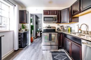 a kitchen with stainless steel appliances and wooden cabinets at Short North Convention Private Parking Pets in Columbus