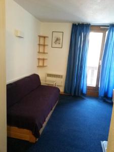 ヴァル・トランスにあるAltineige 4 Pers, Ski-inoutのベッドと青いカーテンの窓がある寝室