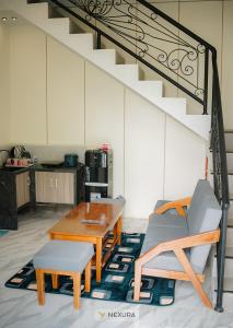 - un salon avec une table, des chaises et des escaliers dans l'établissement Grand House Nexura Collection, à Diyeng