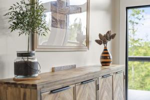 ein Holzschrank mit zwei Vasen darauf in der Unterkunft Luxury Hot-Tub WiFi - A Red River Barnhouse in Campton