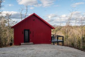 eine rote Scheune mit einer Tür in der Mitte in der Unterkunft Luxury Hot-Tub WiFi - A Red River Barnhouse in Campton