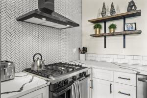 eine Küche mit Herd und Wasserkocher in der Unterkunft Luxury Hot-Tub WiFi - A Red River Barnhouse in Campton