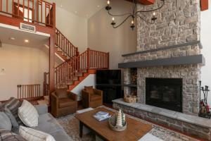 a living room with a fireplace and a couch at Deluxe Ski in-out - HotTub - Fire - PingPong - View in Mont-Tremblant