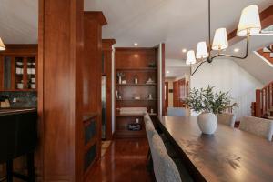 a dining room with a long wooden table and chairs at Deluxe Ski in-out - HotTub - Fire - PingPong - View in Mont-Tremblant