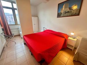 a red bed in a room with a window at Affittacamere Miri in Cagliari