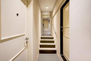 un pasillo con escaleras que conducen a una puerta en Hotel O Siba Inn, en Bombay 27 fotos más
