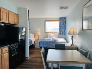 a small hotel room with a bed and a kitchen at Mariner Inn And Suites in Kill Devil Hills