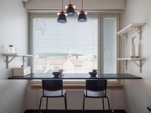 a kitchen with a counter with two chairs in front of a window at Aurora Family Suite in Rovaniemi