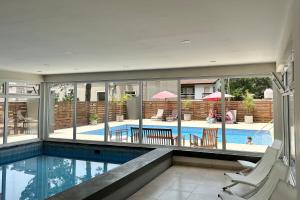 a house with a swimming pool and two chairs at Suite del Sol 106 in Pinamar
