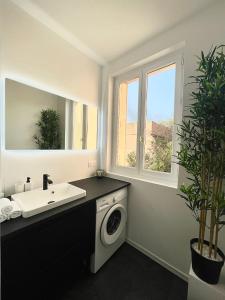 Un baño con lavadora y lavabo. en Élégance & confort - aux portes de Paris, en Aulnay-sous-Bois