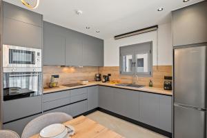 コキノス・ピルゴスにあるArismari Villa 1- Kokkinos Pyrgosの白いキャビネットと木製のテーブルのあるキッチン