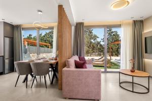 コキノス・ピルゴスにあるArismari Villa 1- Kokkinos Pyrgosのキッチン、ダイニングルーム(テーブル、ピンクの椅子付)