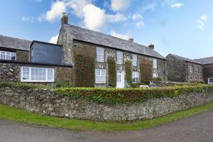 an old brick house with a stone wall at Rose Cottage in Port Isaac