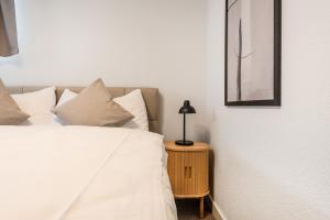um quarto com uma cama e um abajur sobre uma mesa em GOLD-APARTMENT 1 !Gratis Parken, Free Parking! em Frauenfeld
