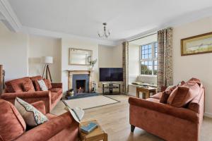 a living room with two couches and a fireplace at Rose Cottage in Port Isaac