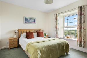 a bedroom with a bed and a window at Rose Cottage in Port Isaac