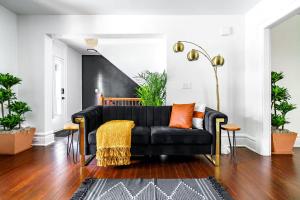 a black couch with orange pillows in a living room at Short North Convention Private Parking Pets! in Columbus