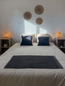 a large white bed with blue pillows on it at Ti ponch in Mont-de-Marsan +6 photos