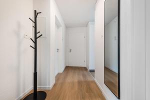 a hallway with white walls and a large mirror at GOLD-APARTMENT 2 !Gratis Parken, Free Parking! in Frauenfeld