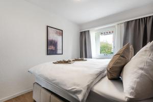 a bedroom with a large white bed with a window at GOLD-APARTMENT 2 !Gratis Parken, Free Parking! in Frauenfeld