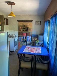 ein Esszimmer mit einem blauen Tisch und einer Küche in der Unterkunft Citón in Salsipuedes