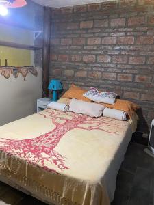 Bett in einem Zimmer mit Ziegelwand in der Unterkunft Citón in Salsipuedes