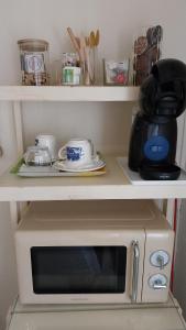 a microwave on a shelf with a coffee pot on it at Casa Serena in Villanueva del Ariscal