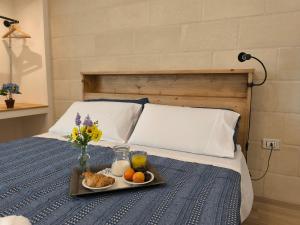 a tray of food on a bed with a tray of fruit at Pietra Bianca in Cutrofiano