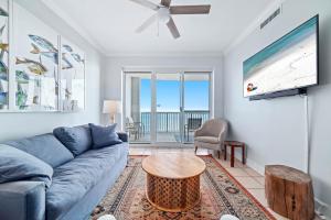 Una sala de estar con un sofá azul y una mesa. en Island Royale P502, en Gulf Shores