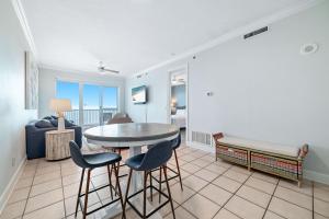 Una sala de estar con una mesa y sillas y un sofá. en Island Royale P502, en Gulf Shores