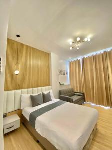 ValenciaにあるValencia Cozy Suitesの大きな白いベッドと椅子のある寝室