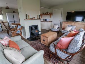 un salon avec un canapé, des chaises et une cheminée dans l'établissement The Dairy, à Glasserton