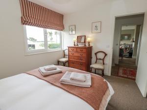 une chambre avec un lit avec deux serviettes dessus dans l'établissement The Dairy, à Glasserton