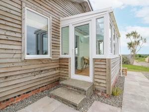 une porte d'entrée d'une maison avec des fenêtres dans l'établissement The Dairy, à Glasserton