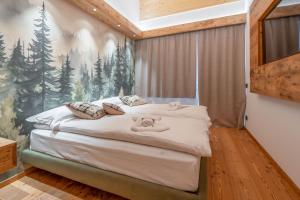 ein Schlafzimmer mit einem Bett und einem Gemälde an der Wand in der Unterkunft BRENTA ALTA ALPINE LODGE MhD in Madonna di Campiglio