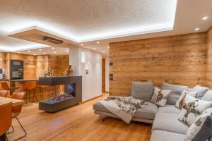 ein Wohnzimmer mit Couch und Kamin in der Unterkunft BRENTA ALTA ALPINE LODGE MhD in Madonna di Campiglio