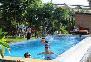 a group of people swimming in a swimming pool at Villa Đăng HảI in Buôn Du Enguôl