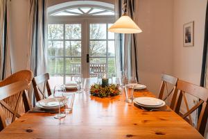 a dining room table with chairs and a large window at Ferienwohnung "Wildgans" in Schaprode +11 photos
