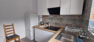 a small kitchen with white cabinets and a sink at Anna's centrum apt in Artemida +12 photos