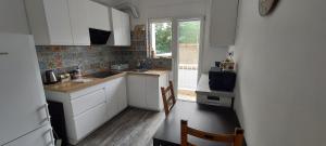 a small kitchen with white cabinets and a window at Anna's centrum apt in Artemida