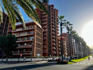 een hoog gebouw met palmbomen naast een straat bij Sunrise Serenity in Puerto de la Cruz in Puerto de la Cruz