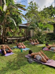 a group of people doing yoga in the grass at Pousada Caraíva in Caraíva