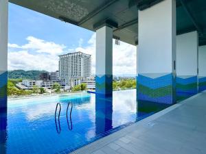 una piscina con vista a un edificio en Bay Suites l Seaview l 8 Pax l SICC l 沙巴全海景民宿, en Kota Kinabalu