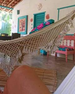 a hammock in a room with a bed at 4eTal Trancoso in Trancoso