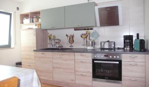 AltengronauにあるFerienwohnung in ehemaliger Bankの白いキャビネットとコンロ付きオーブンを備えたキッチン