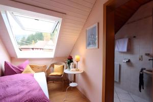 a bedroom with a bed and a window and a table at Gasthaus Zur Linde Ferienwohnungen in Langhard