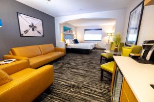 a hotel room with a couch and a bed at Creekside Hotel & Suites in Canyonville