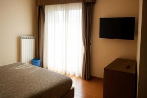 a bedroom with a bed and a window with a television at Agriturismo Il Falco in Velletri