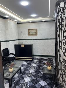 une pièce avec une télévision, deux tables et un canapé dans l'établissement Aswan City Star, à Assouan